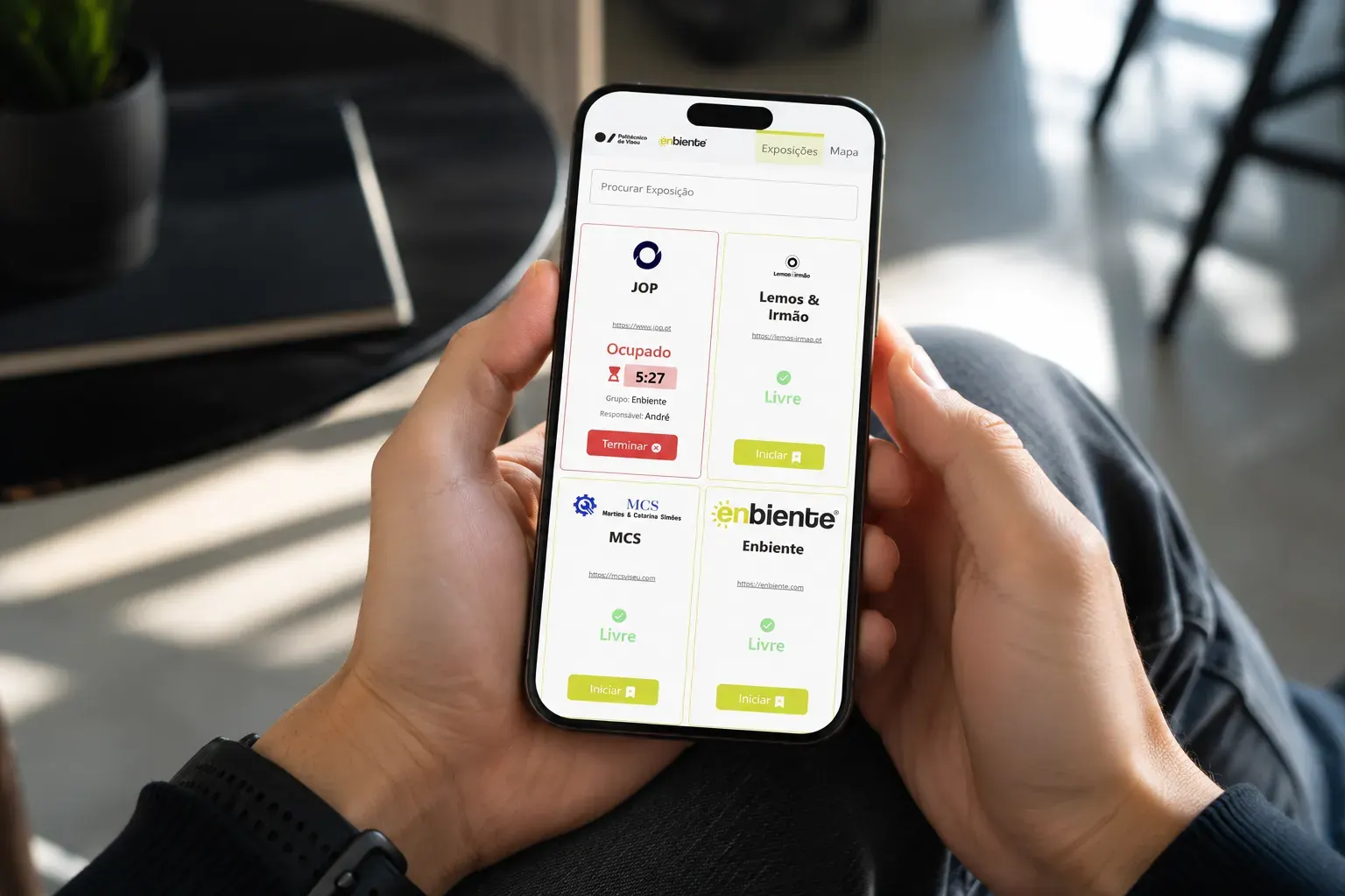 A web app do DEE Open Day num telemóvel: a lista de stands das empresas, cada um marcado como Livre ou Ocupado com um cronómetro, e botões para iniciar ou terminar a visita. No topo, os logótipos do Politécnico de Viseu e da Enbiente.